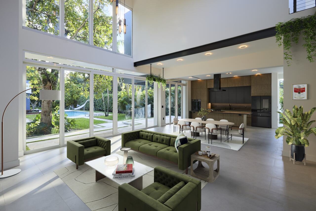 Double-height interior living space with garden views and integrated kitchen